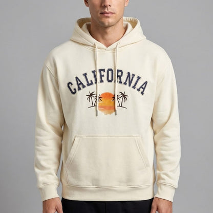 Man wearing a cream hoodie with 'California' and palm tree design on a gray background
